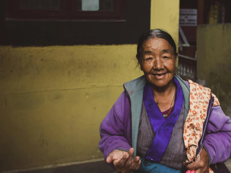 the woman is sitting outside of her home