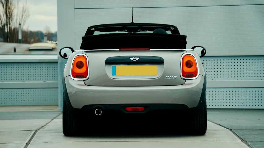 a silver sports car is parked near a garage