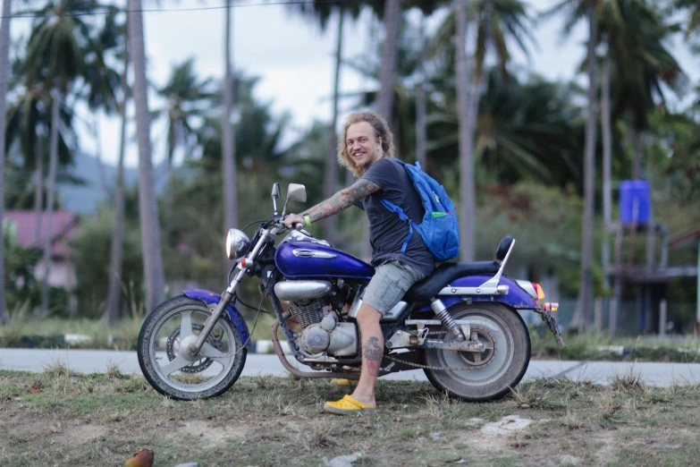 a man with a backpack sits on a motorcycle