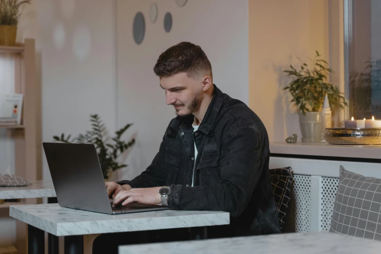 a man using a laptop on his table in a restaurant