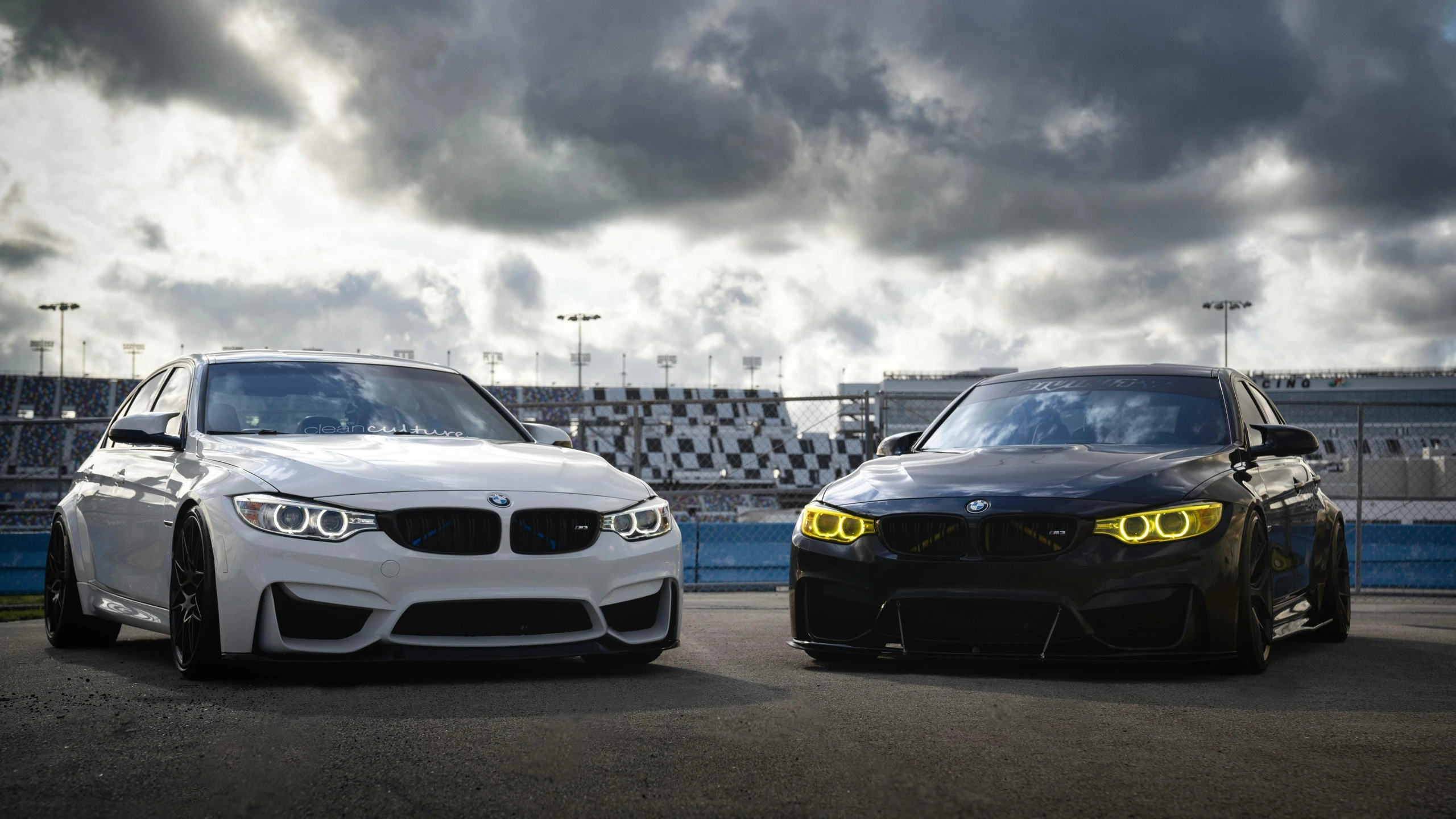 two cars parked side by side in the middle of a track