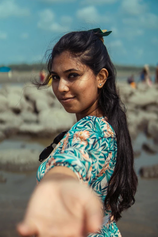 a woman pointing at soing on the beach