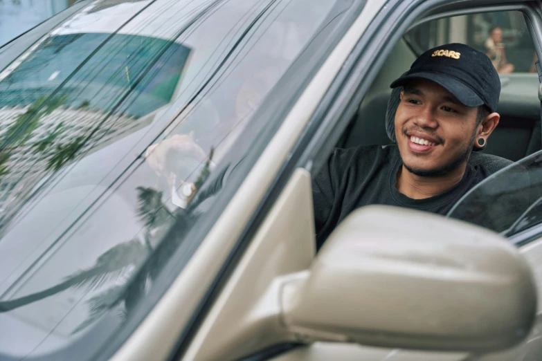 the young man is sitting in the car smiling