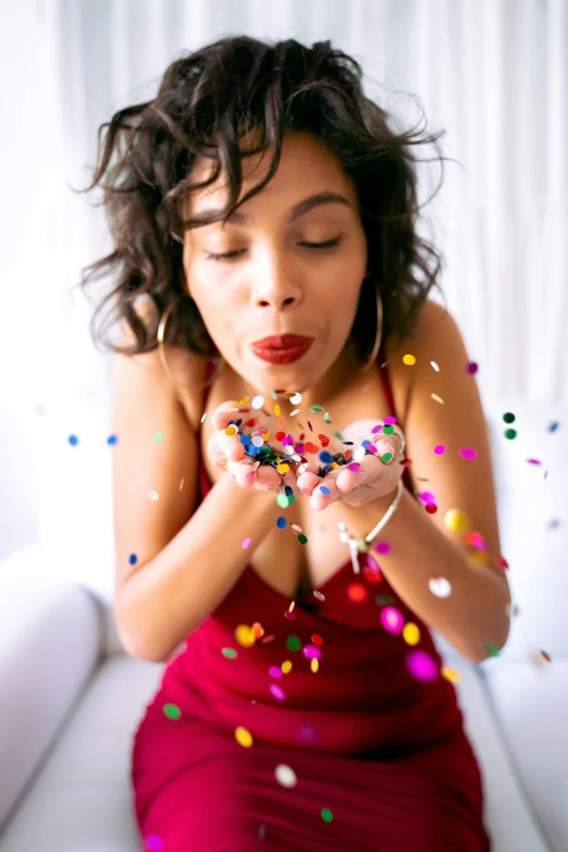 a woman holding a ring surrounded by confetti