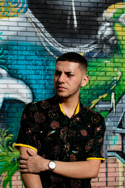 man standing in front of a colorful wall with the mural behind him