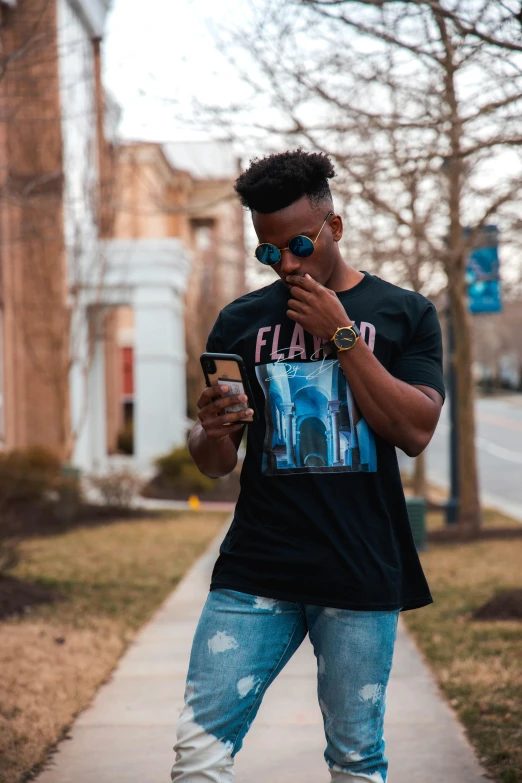 a man in blue jeans holding a smart phone