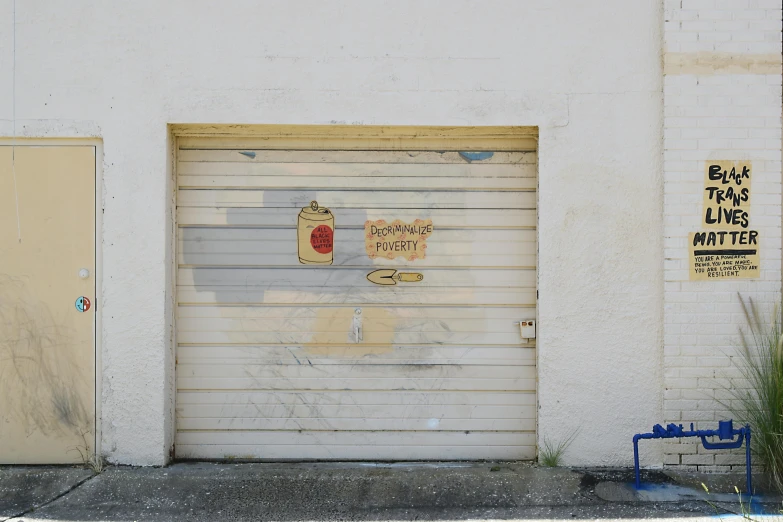 a closed garage door with two signs posted on it
