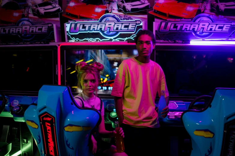 a girl in front of a man standing next to a video game machine