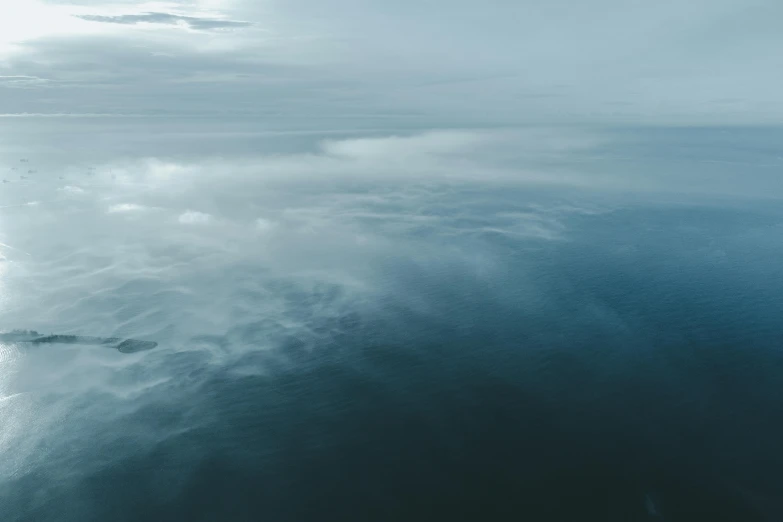 a large body of water with clouds floating over it