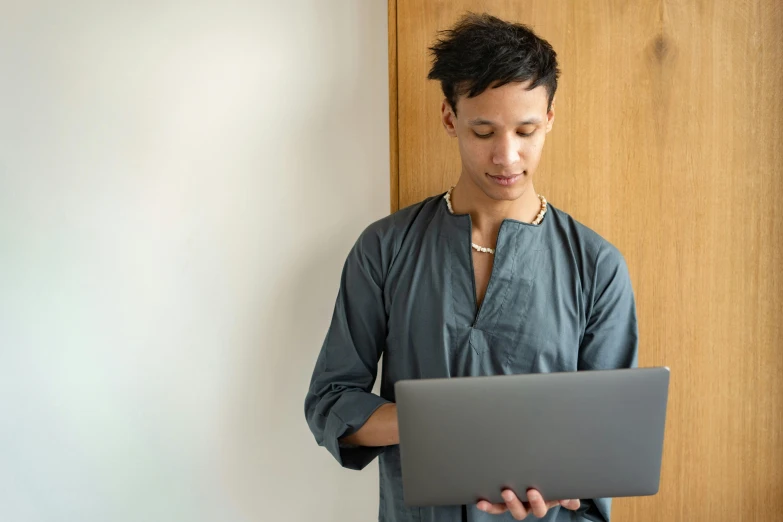 a man holding onto his laptop computer and staring at it