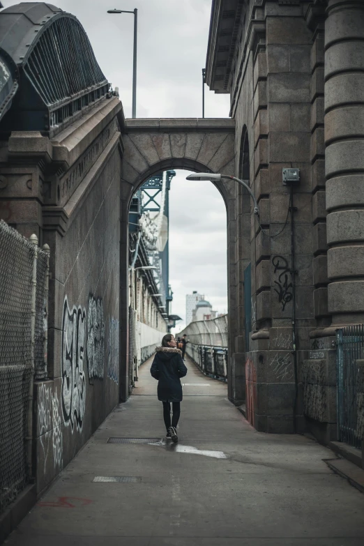 a woman walking in the middle of an old brick street