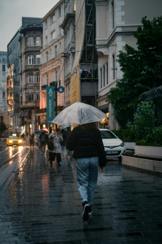 a man walking down the street while holding an umbrella