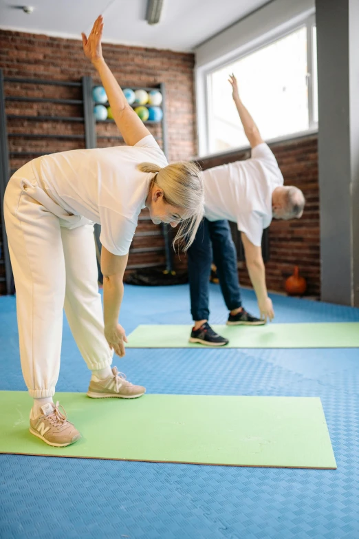 two people on yoga mats with one doing the splits