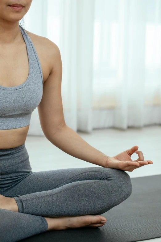 a woman in grey sports  tops practicing yoga