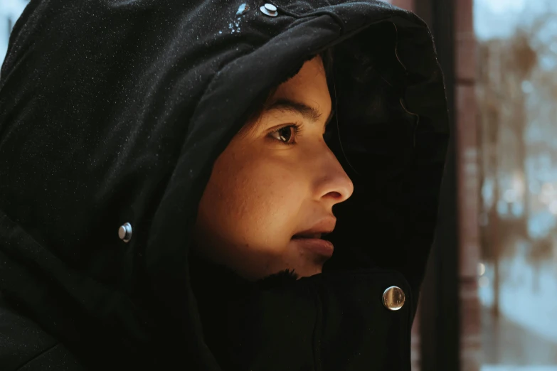 a young person wearing a hooded jacket in winter