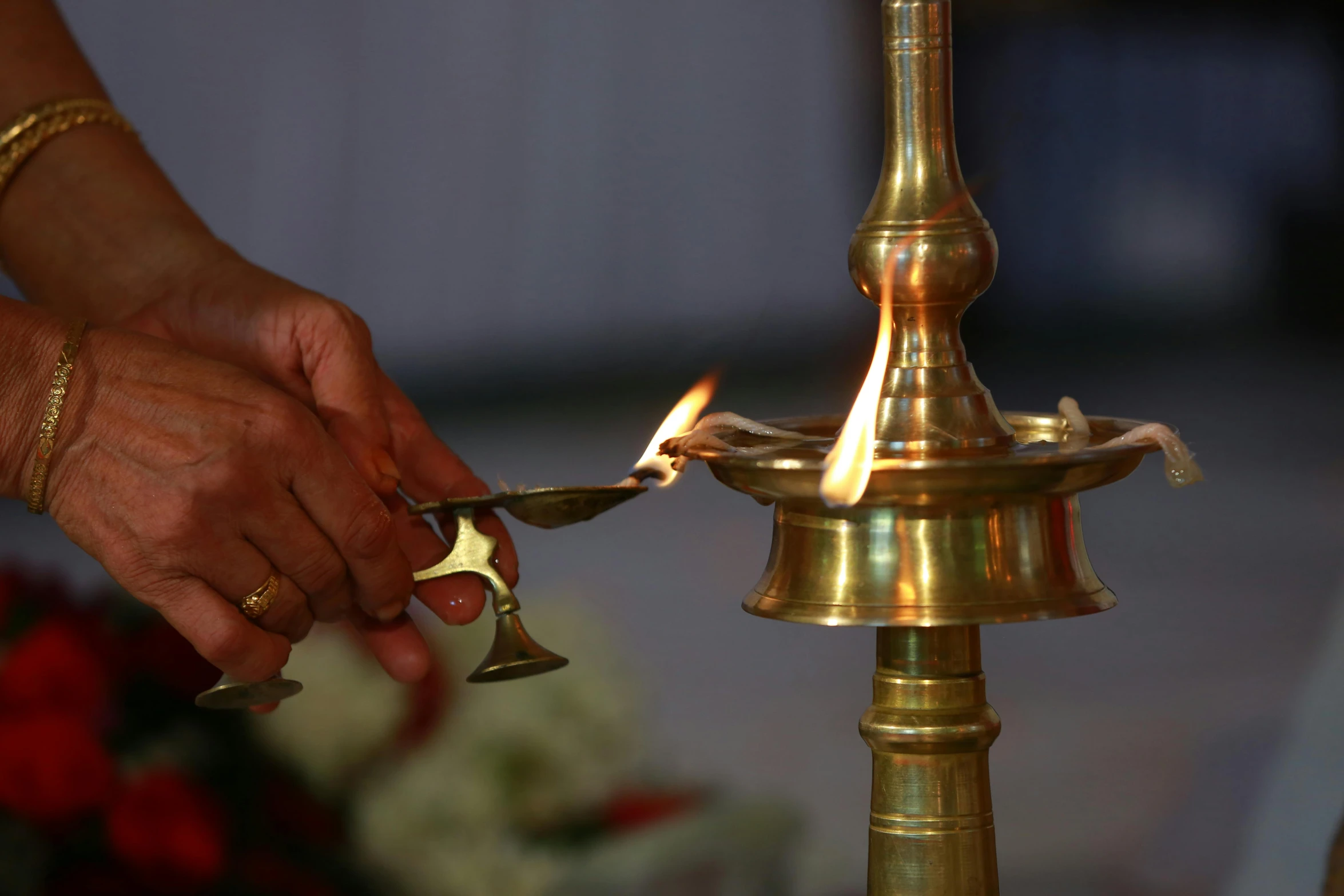 the women is lighting up the candles on the small pole