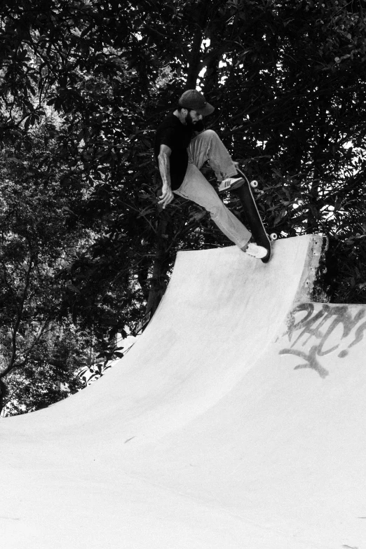 black and white pograph of skateboarder mid - jump