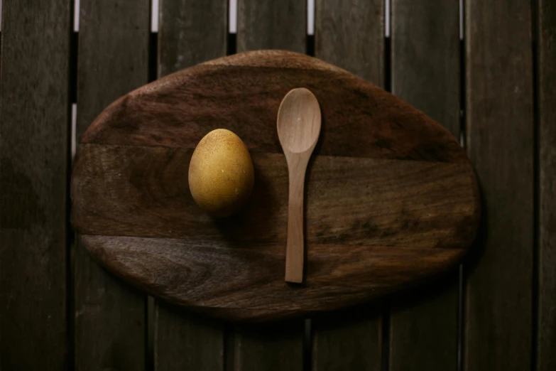 two pears, a spoon and a wooden board sitting on wood