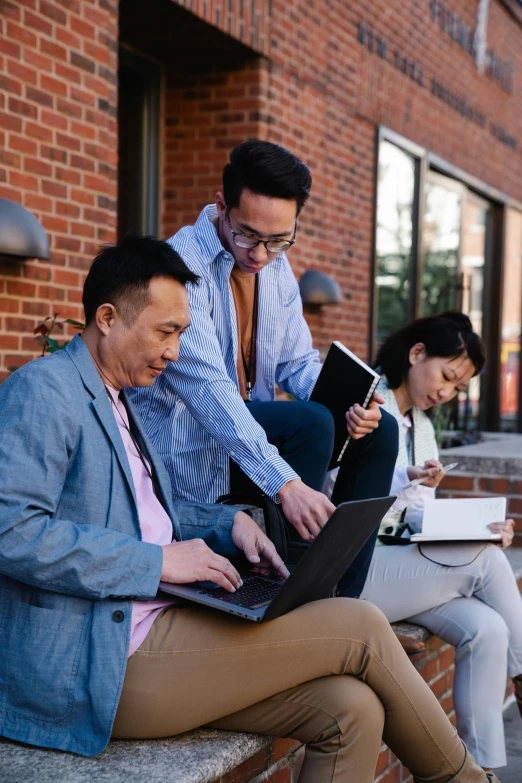 a group of people sitting around each other on a brick wall