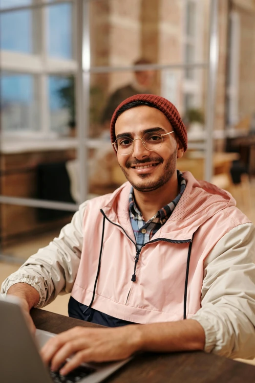 a smiling man using a laptop computer