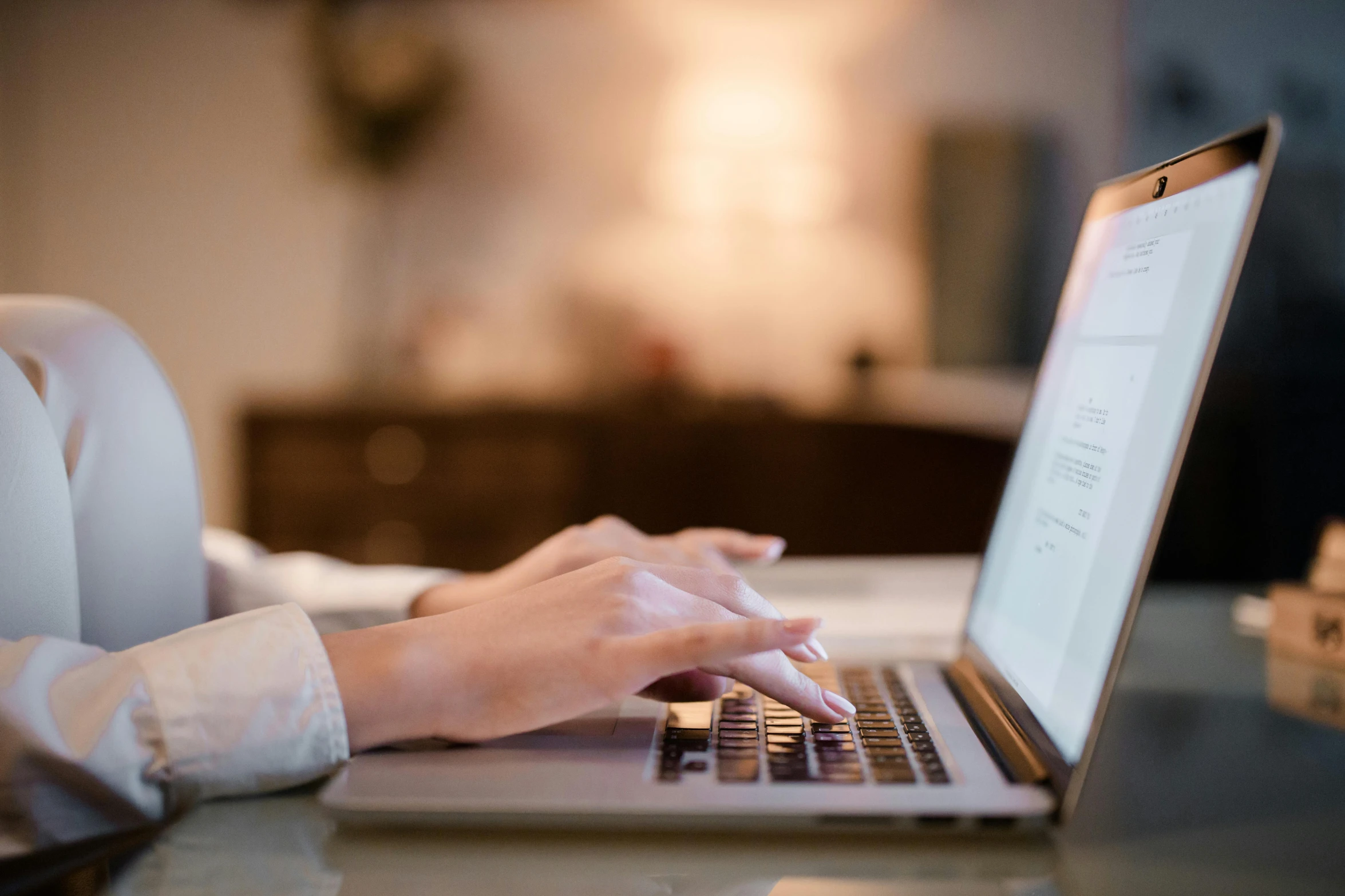 a woman working on a laptop while sitting in a chair