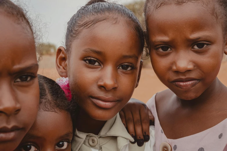 three little girls posing for a po outside