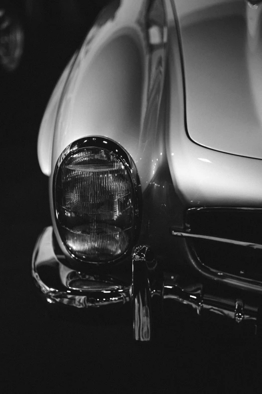 the headlights of an old style sports car in black and white