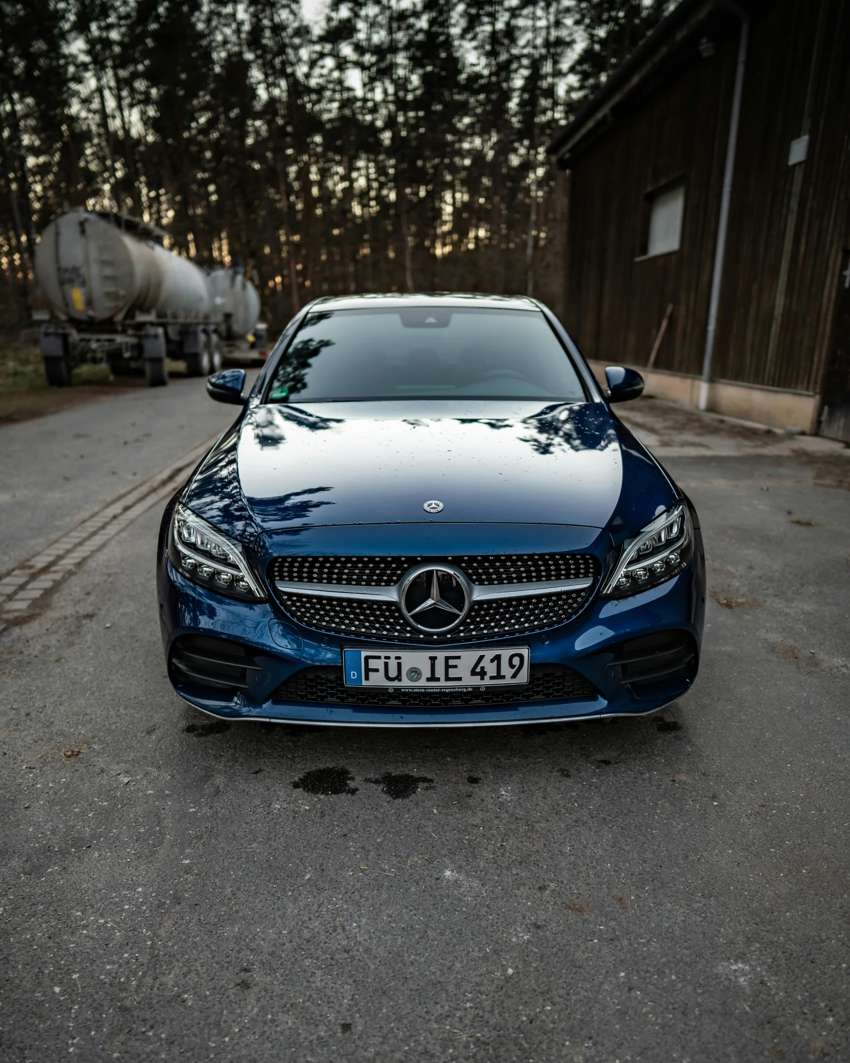 the mercedes benz c63 amg blue car is parked on the asphalt