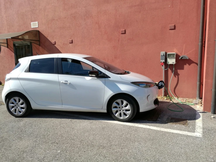 a white car parked next to an orange building