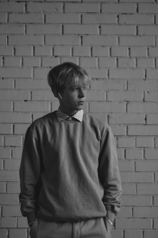 a man standing in front of a brick wall