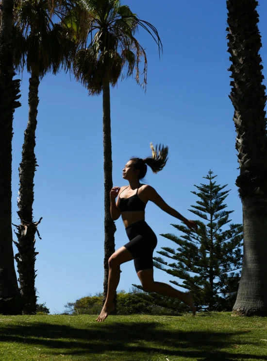 a woman is jumping up in the air while wearing a bikini top