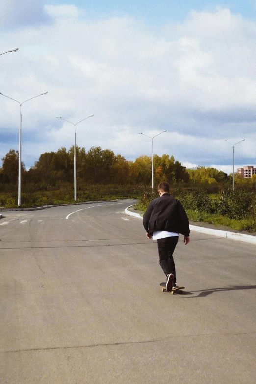 a person in black jacket riding a skateboard on street