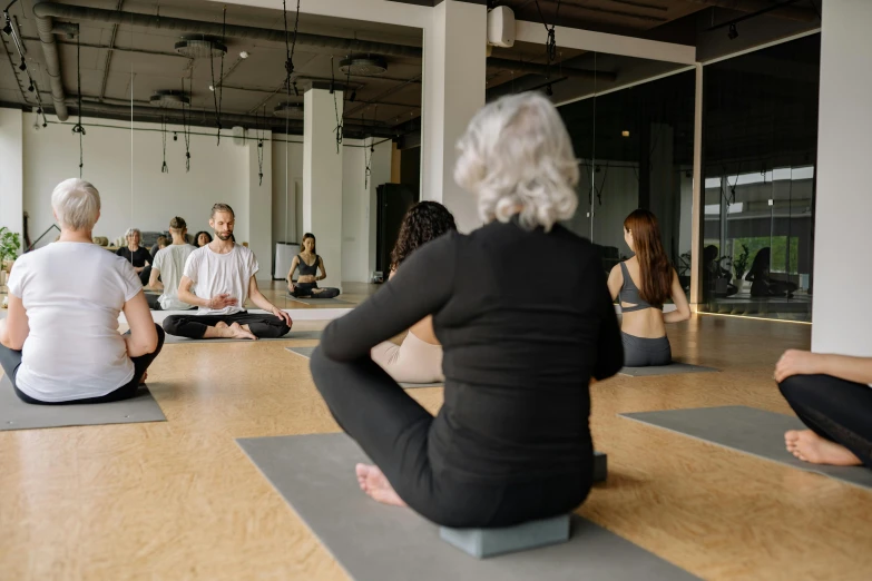 a group of people are seated on yoga mats