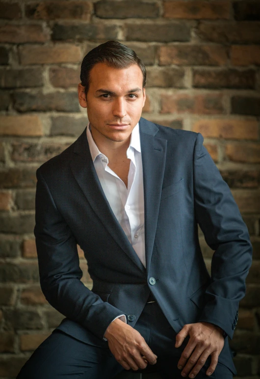 a young man in blue jacket and white shirt posing for a po