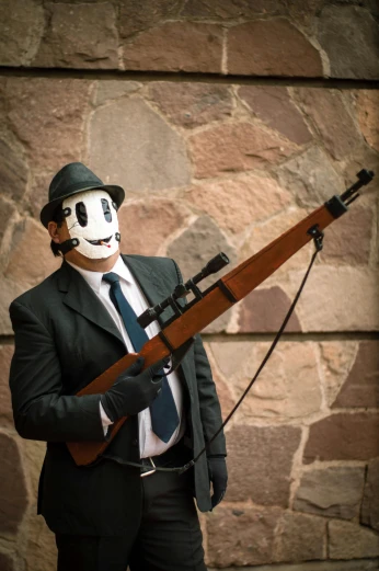 a man in a suit holding a gun with a mask on