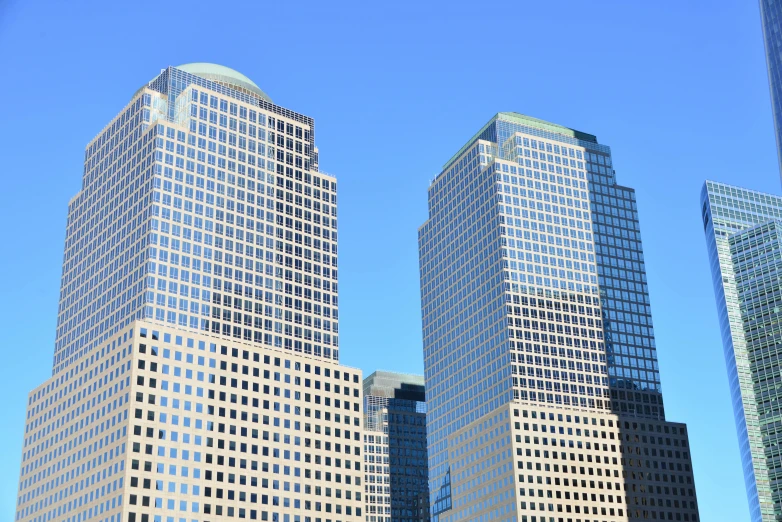 three tall buildings in the background of a clear sky