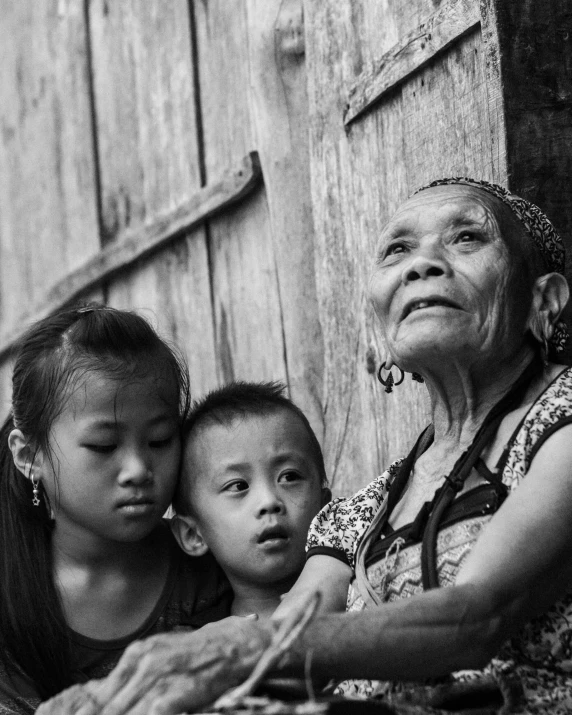 a mother and her two children are sitting on the ground