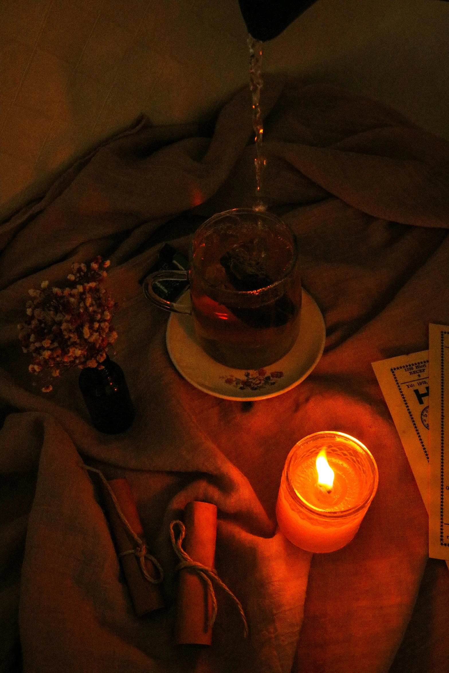 a dark po with candles on the table and a plate