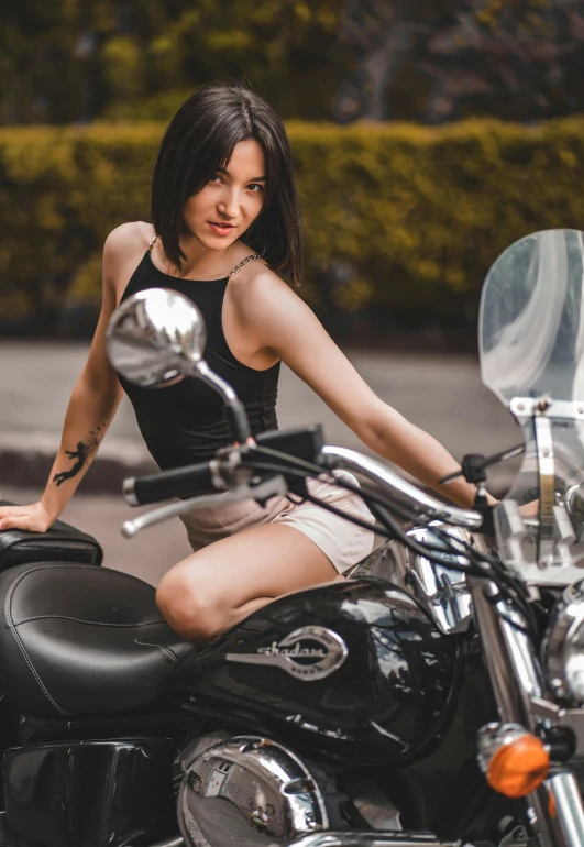 a young lady sitting on a parked motorcycle