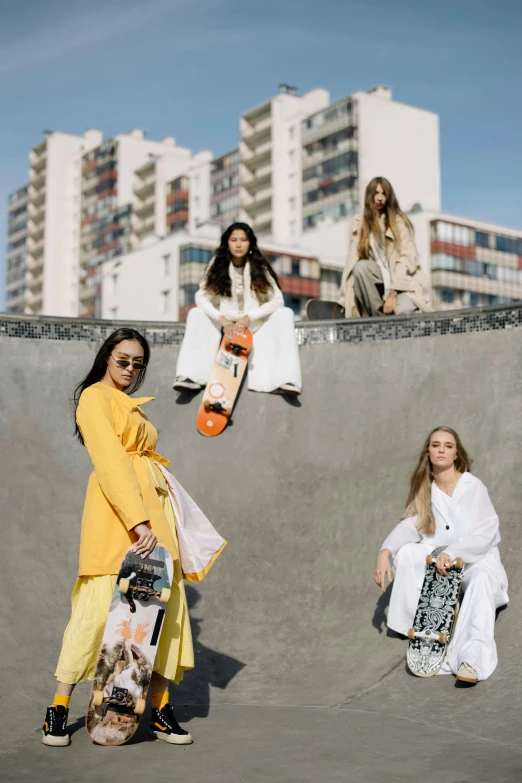 women in skateboards are at the skate park while another woman is sitting on the ramp