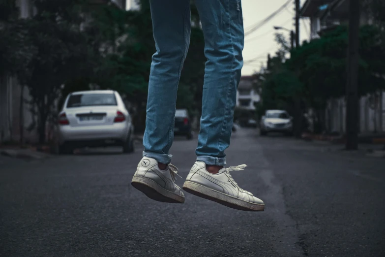 a person that is wearing sneakers jumping in the air