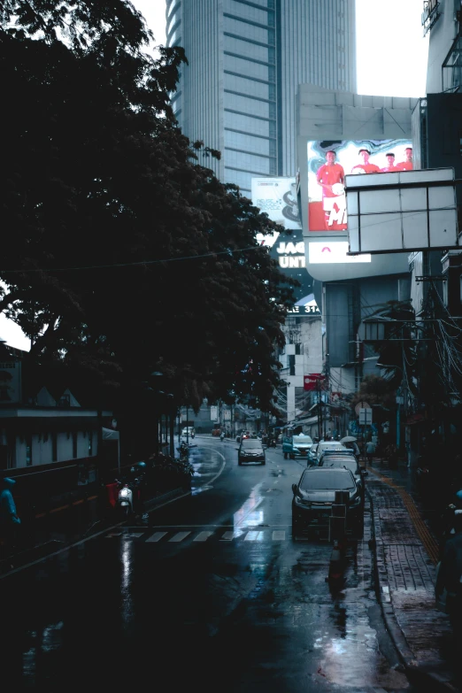 a city street in the rain with tall buildings