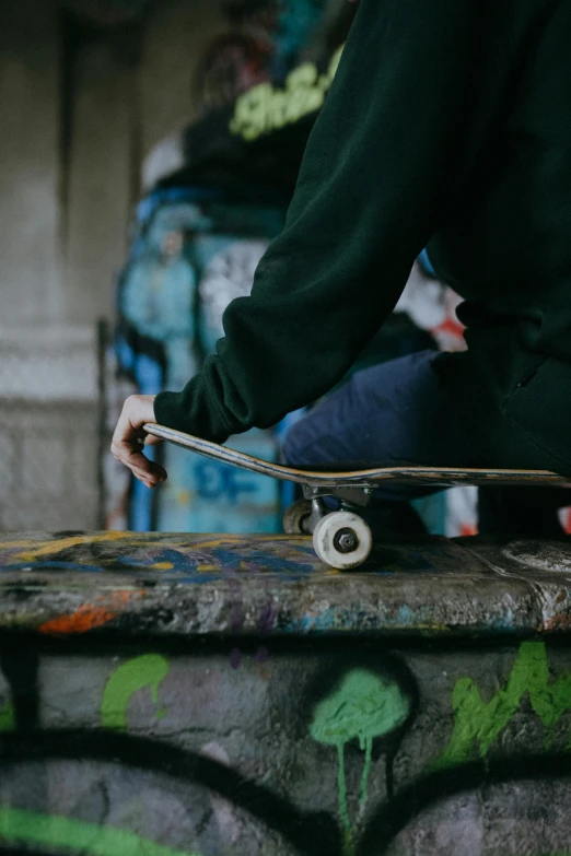 the skateboarder is sitting down on the wall