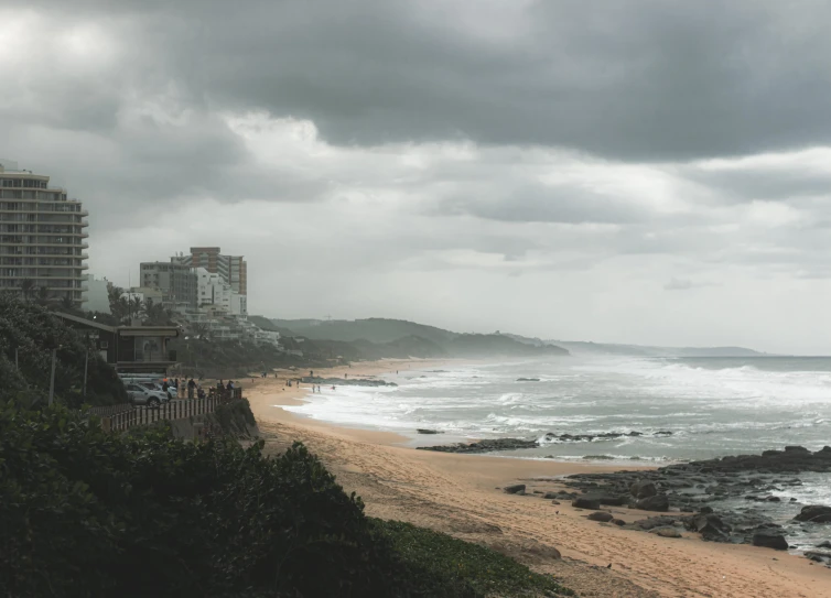 some buildings are overlooking the ocean with clouds in the background