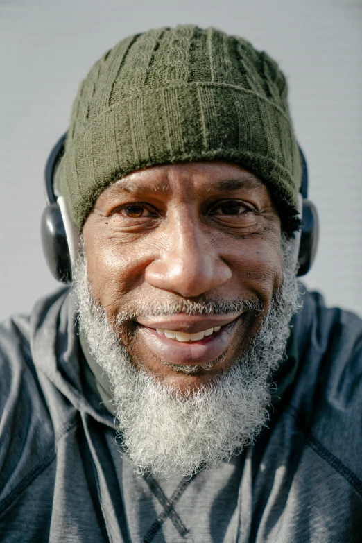 a man with ear phones on and wearing a beanie