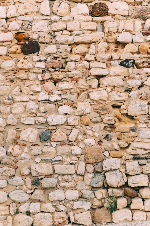 a wall made of stones sits next to a brick building