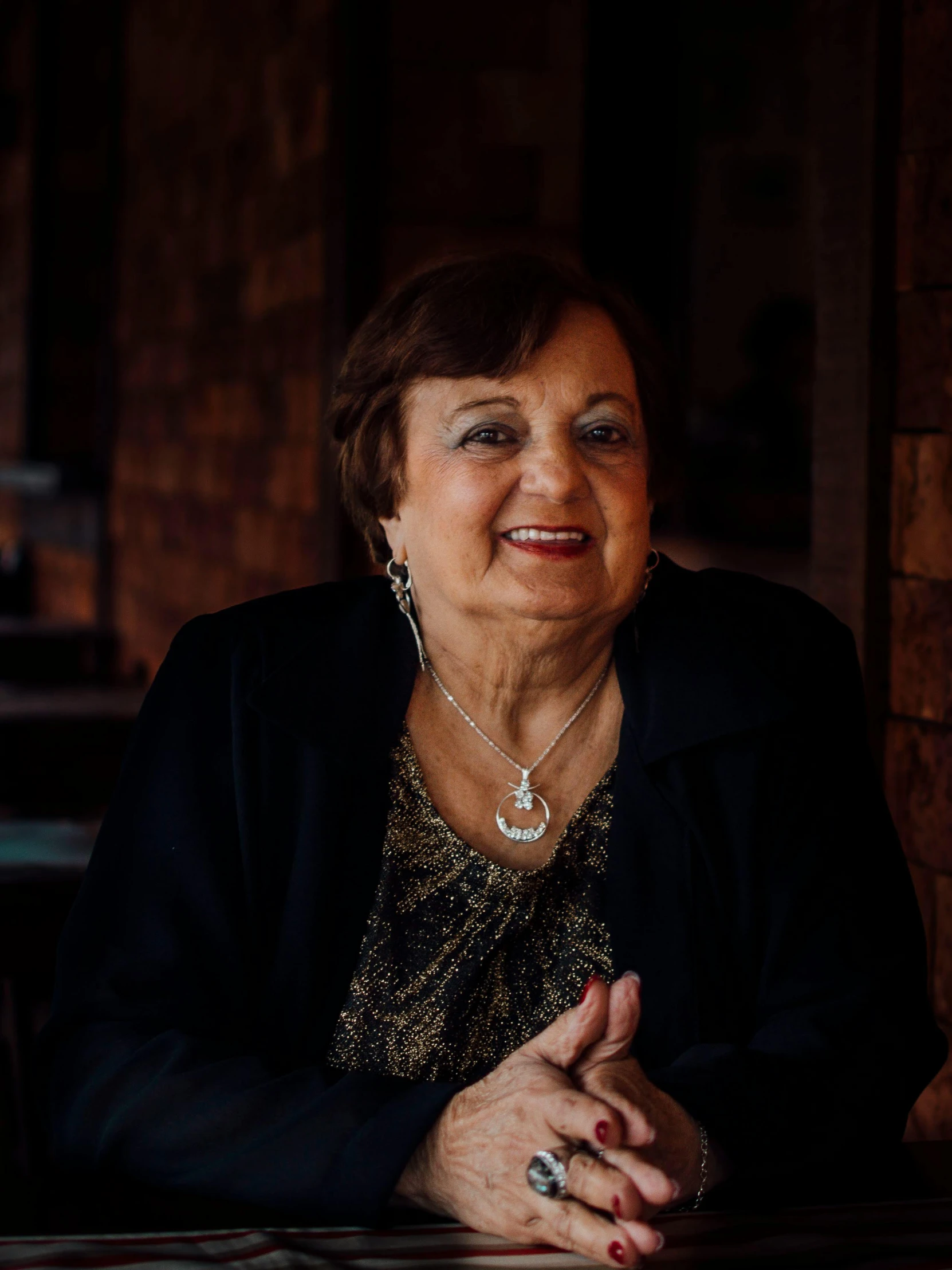 a woman with a necklace sitting at a table