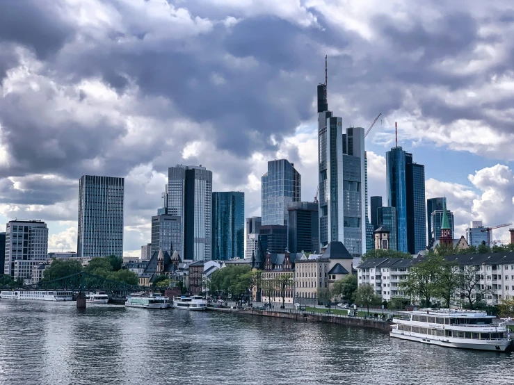 boats in a river near a city on a cloudy day