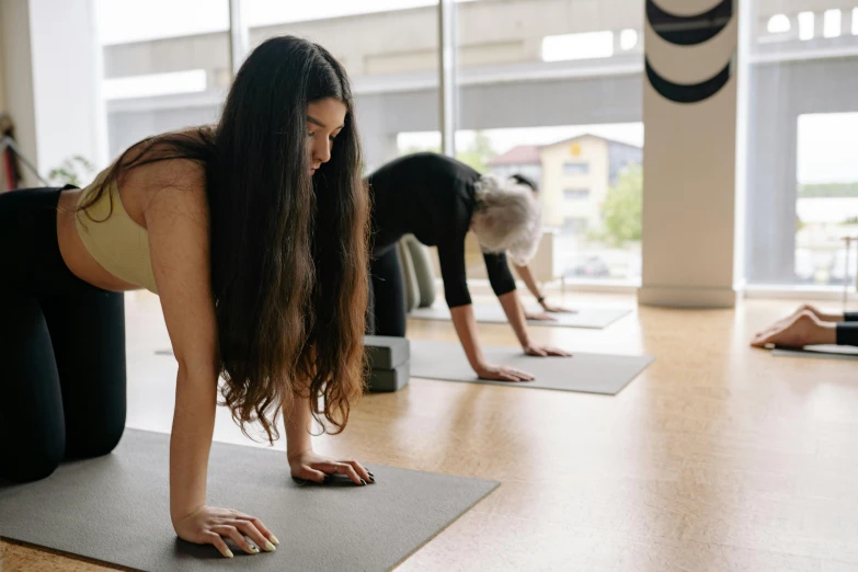 two women are practicing yoga in front of a mirror