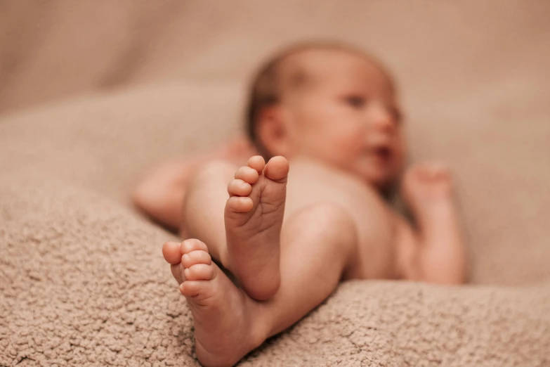 a baby lays down on a blanket